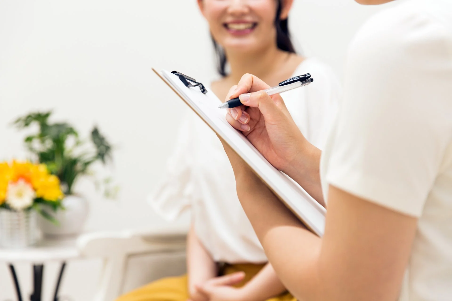 カウンセリングで肌と身体の悩みを聞き取る施術スタッフとお客様の手元